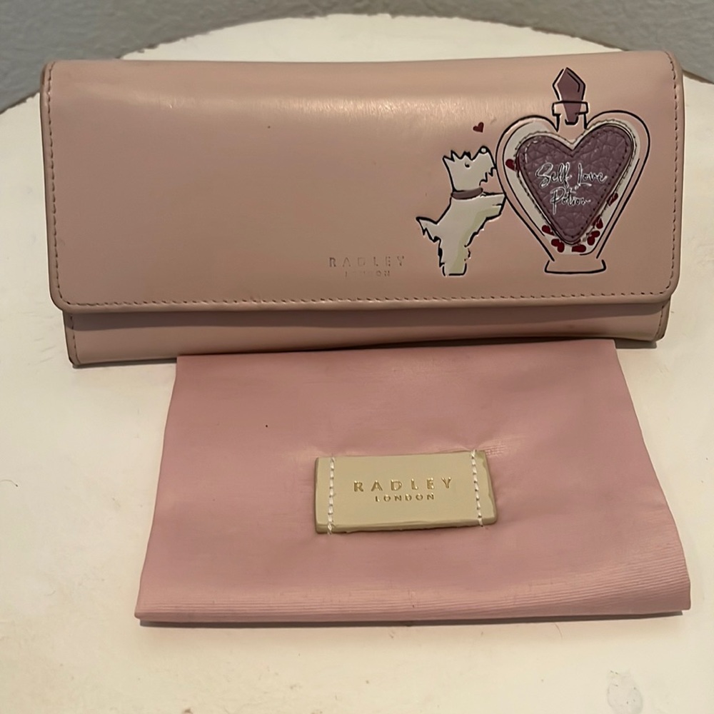 Super cute pale pink Radley London wallet w  duster. Print on front faded.
